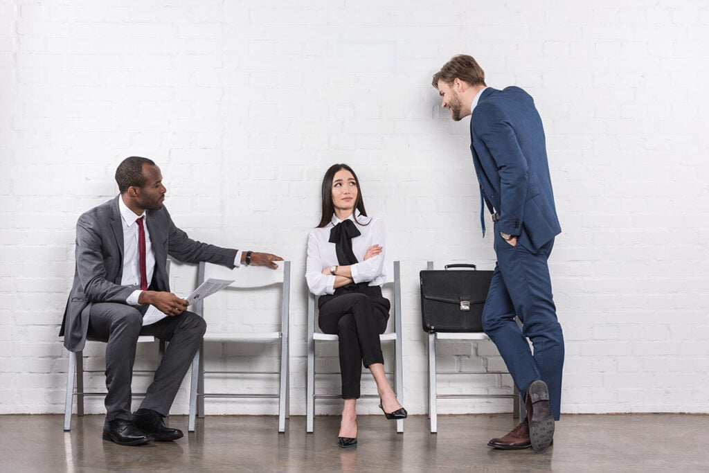 Two professionals engaged in a serious conversation with a third observing, evoking themes of workplace dynamics handled by Pentana Stanton's employment law services.