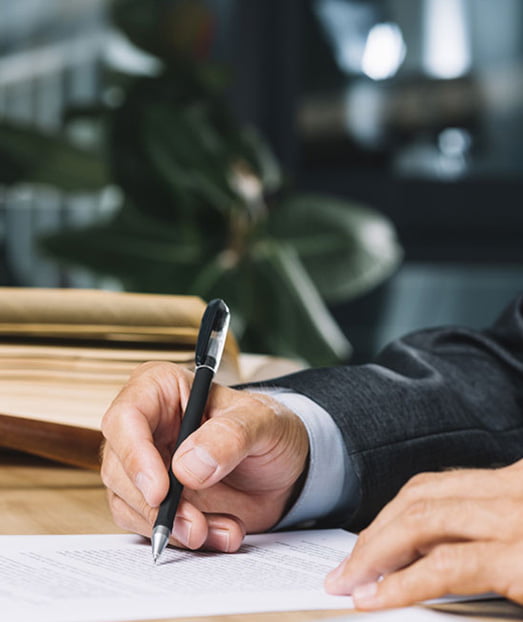 Lawyer reviewing legal documents with pen in hand.