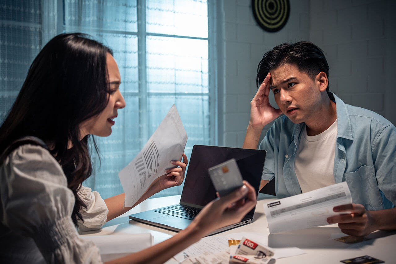 Stressed couple with financial documents in Melbourne, highlighting the need for legal financial advice.