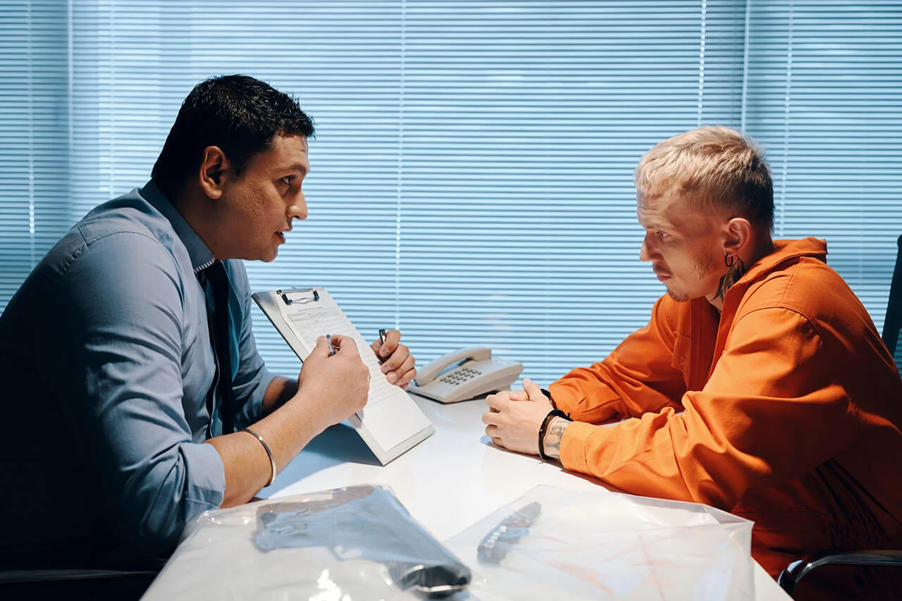 A criminal defence lawyer in Melbourne consults with a client, discussing legal documents in a focused meeting.