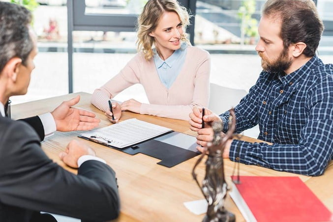 Couple consulting with a lawyer about contesting a will.