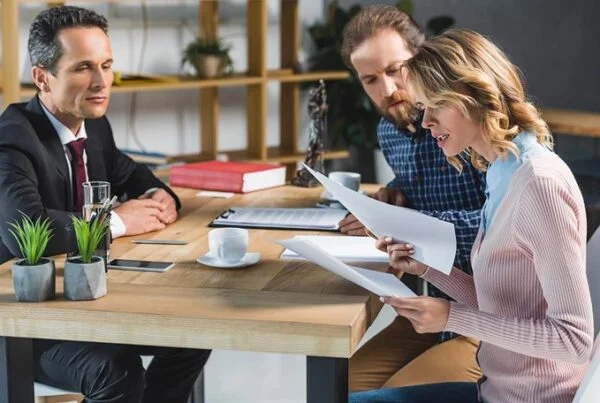 Man and woman consulting with a lawyer over documents.