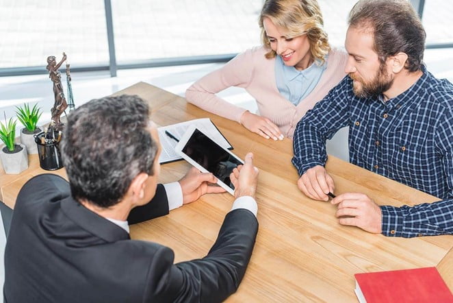 Couple consulting with a lawyer using a tablet.