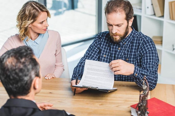 Man and woman consulting with a lawyer over a legal document