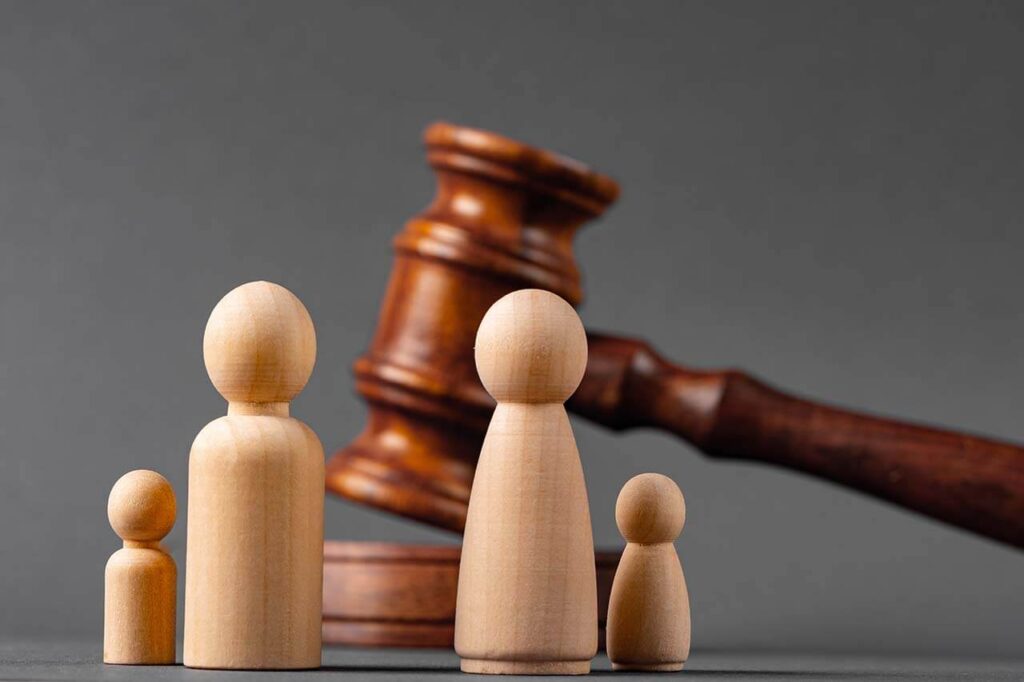 Wooden figurines representing a family with a gavel, symbolising family law and legal matters.