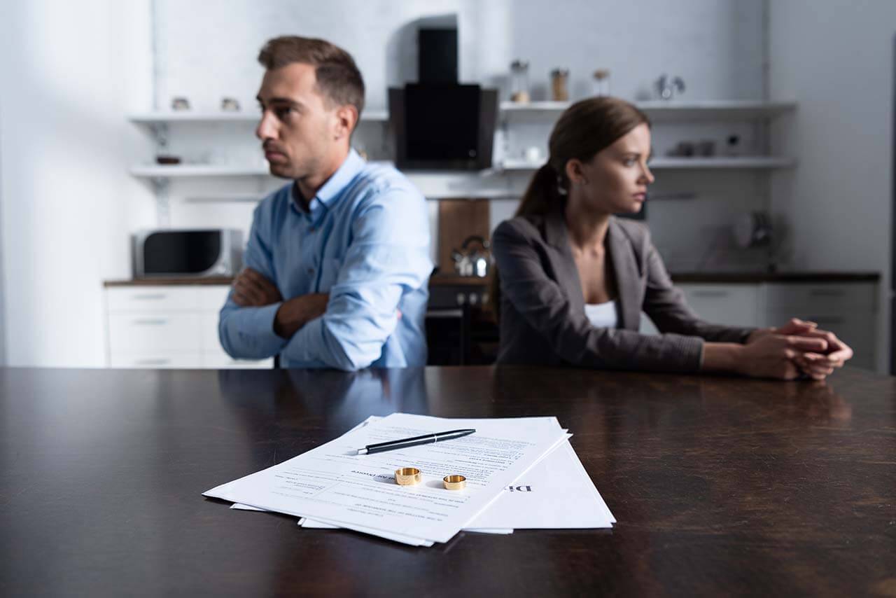 Divorcing couple with divorce papers and rings on the table.