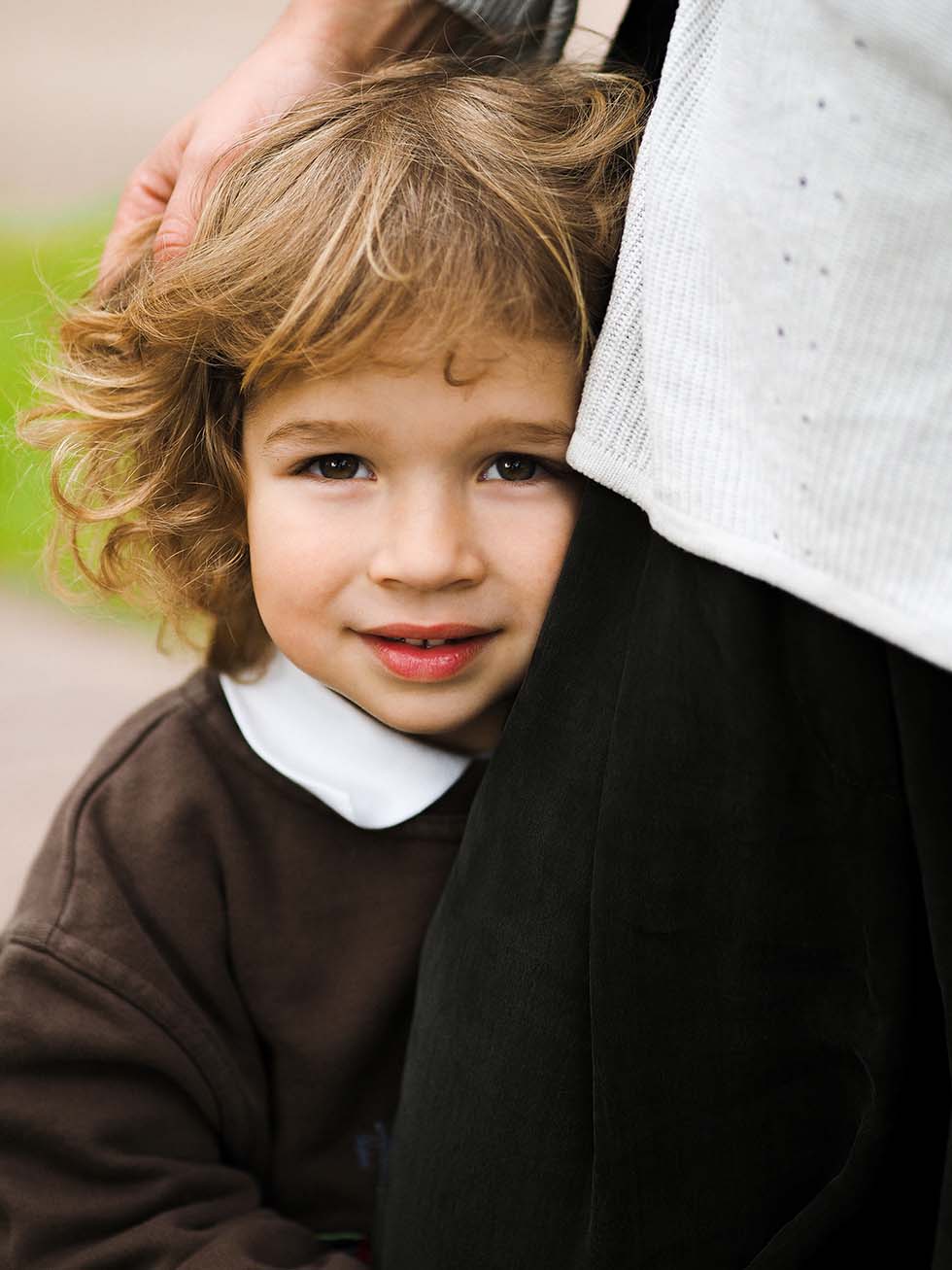 Young child standing with a parent, representing family law matters involving DFFH.