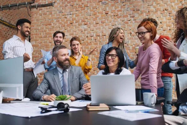 Lawyers in Melbourne CBD fostering a positive workplace culture with a diverse team celebrating success, offering guidance on employment law FAQs.