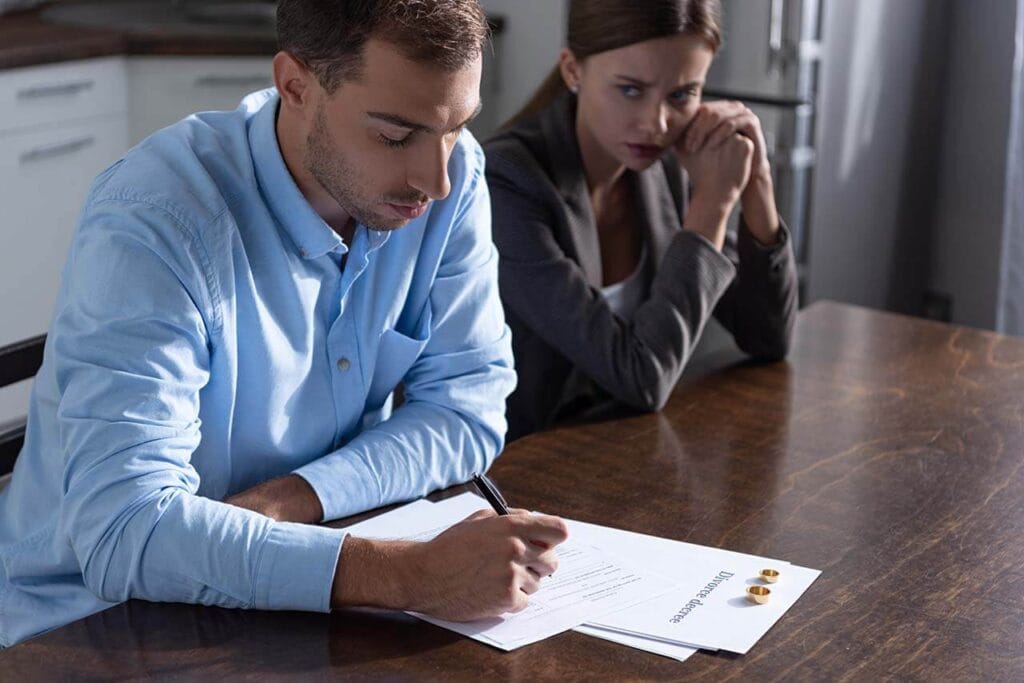 Melbourne couple signing divorce papers during mediation.